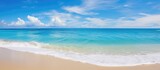 The breathtaking beauty of the beach during summer with its turquoise blue sea stunning landscape and golden sand is enhanced by the warm sunlight clear sky and fluffy clouds reflecting in 