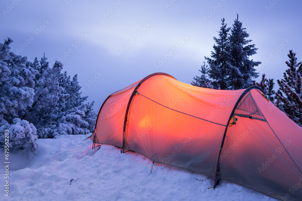 Illuminated tent in a white winter landscape at night