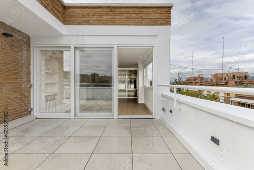 Terrace with white stoneware floor  large window with three aluminum and white glass doors and combined white brick and mud walls