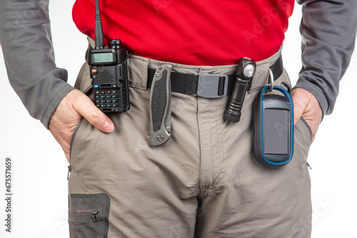 walkie-talkie, flashlight, knife, GPS navigator on the belt of the tourist trekking pants. equipment for tourism and travel. EDC items