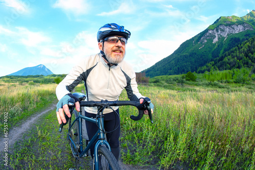 bearded man cyclist rides a bike on a road in nature. sports, hobbies and entertainment for health