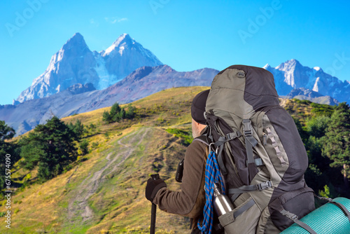 man traveler with hiking equipment on mountain landscape background. nature hikes in the mountains
