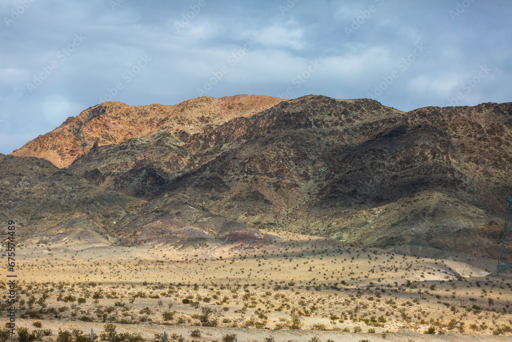 View of Mojave Desert national reserve landscape, an arid rain-shadow desert, California, United States of America, summer sunny day with road, mountains, sand dunes and a blue sky View of Mojave Desert national reserve landscape, an arid rain-shadow desert, California, United States of America, summer sunny day with road, mountains, sand dunes and a blue sky