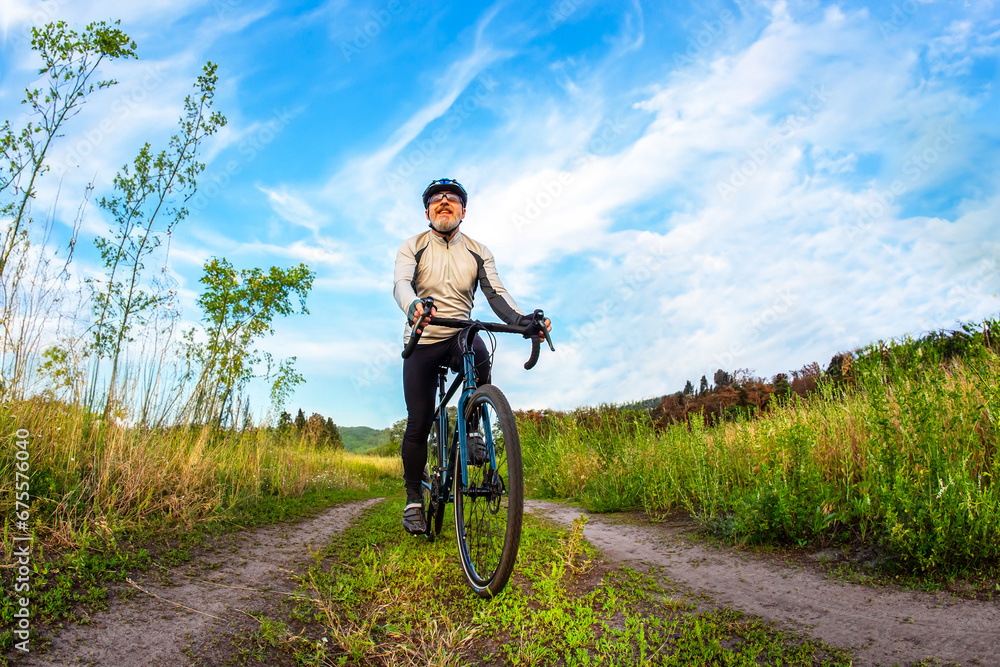 bearded man cyclist rides a bike on a road in nature. sports, hobbies and entertainment for health bearded man cyclist rides a bike on a road in nature. sports, hobbies and entertainment for health