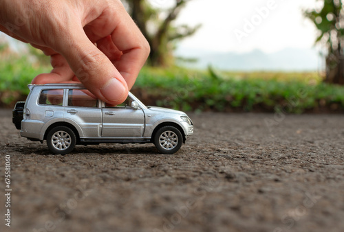 Concept for outdoor activities with toy for children. Photo of a toy car held by hand. After some edits. photo