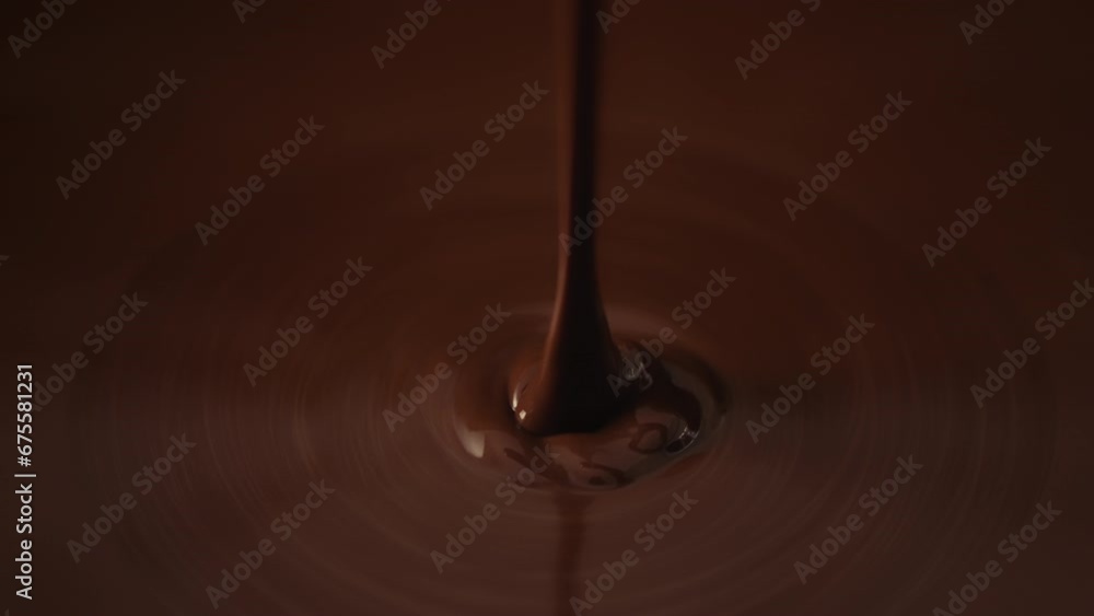 Slow motion shot pouring melted chocolate, close-up seamless dripping hot liquid chocolate flows, waves flowing molten chocolate or dark caramel sauce. Chocolate wavy drip. Confectionery cooking Slow motion shot pouring melted chocolate, close-up seamless dripping hot liquid chocolate flows, waves flowing molten chocolate or dark caramel sauce. Chocolate wavy drip. Confectionery cooking