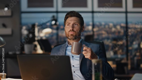 Pensive businessman drinking tea in night office closeup. Director taking break photo
