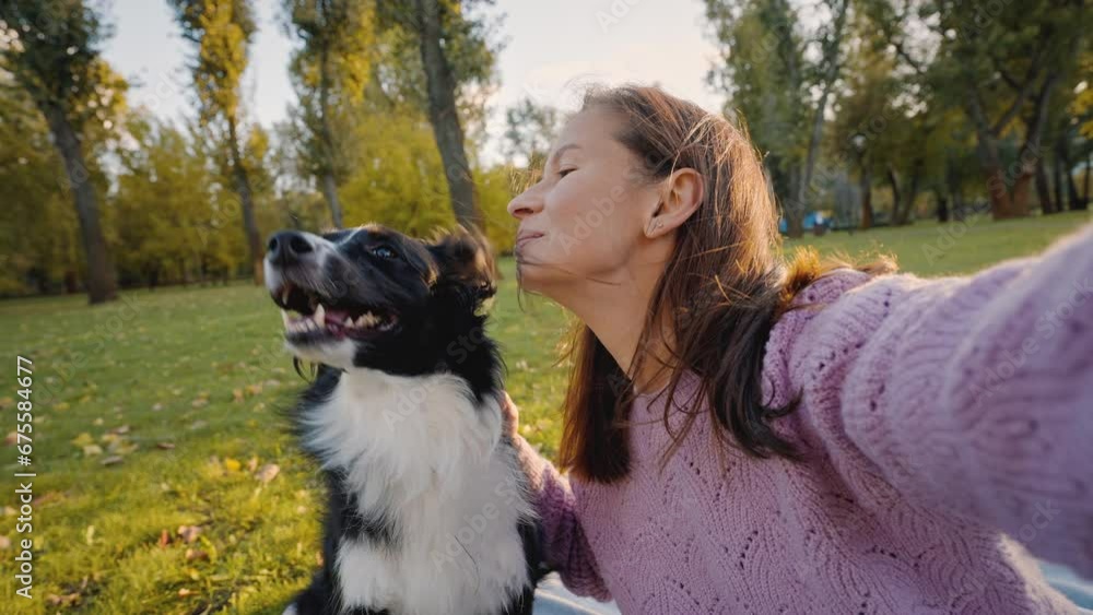Positive female takes ridiculous selfie with dog in park Positive female takes ridiculous selfie with dog in park