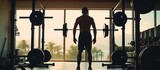 Man exercising with barbell. Male bodybuilder doing weight training in the gym, view from behind.