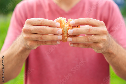 A guy's hand holds a mini puff pastry with cheese, snack and fast food concept. Selective focus on hands