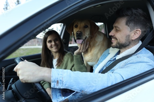 Happy couple and dog in car. Traveling with pet © New Africa