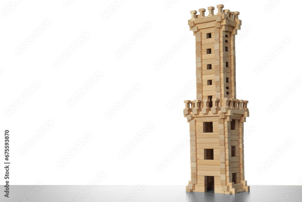 Wooden tower on light grey table against white background, space for text. Children's toy