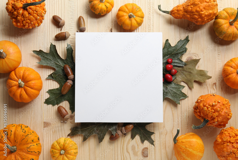 Fototapeta premium Thanksgiving day. Flat lay composition with pumpkins and blank card on light wooden table, space for text