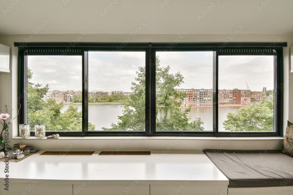 Fototapeta premium a window with a view of the water and buildings in the distance, as seen from an empty office space