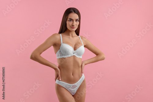 Young woman in elegant white underwear on pink background © New Africa