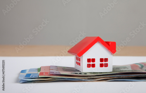 small house and mexican peso banknotes. Buying a new house, home loan, mortgage and real estate concept