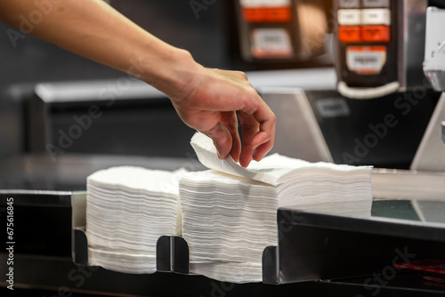 hand pick tissue paper and napkin pile on service table in restaurant 