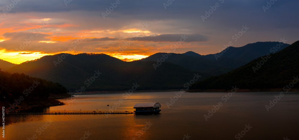 Mountains lake landscape in rainy season with sunset sky and clouds