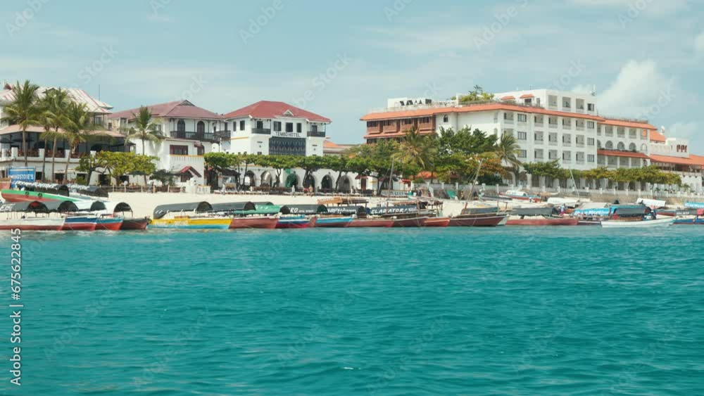 Stone Town Zanzibar beach with colorful boats and clear blue water. View from the water. Stone Town Zanzibar beach with colorful boats and clear blue water. View from the water.