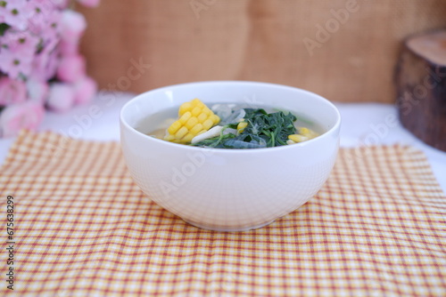 Sayur Bening Daun kelor jagung or Moringa Oleifera clear soup with sweet corn served in bowl photo