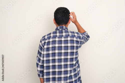 Schilderij op canvas Back view of a man scratching his head showing confuse expression