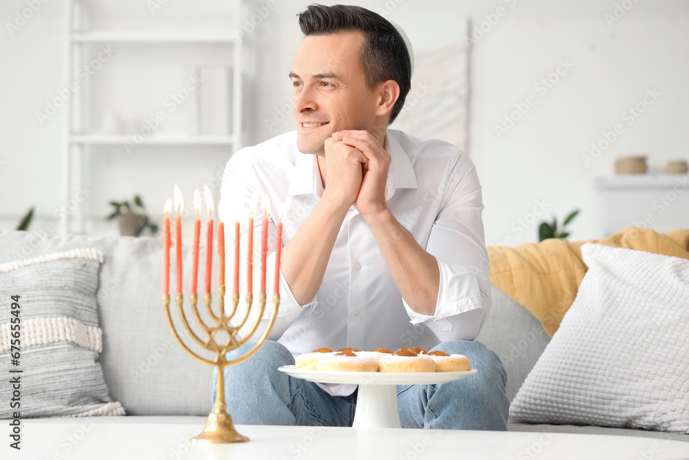 Young man celebrating Hanukkah at home Young man celebrating Hanukkah at home