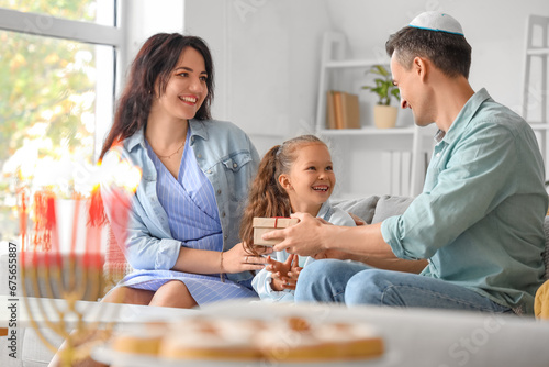 Happy family with gift celebrating Hanukkah at home photo