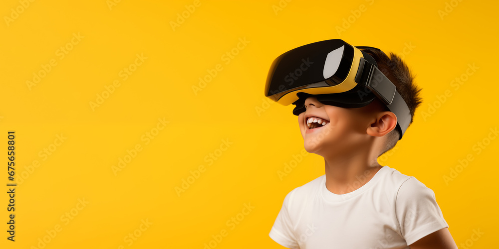 Young boy getting experience using VR headset glasses isolated on a yellow background with copy space