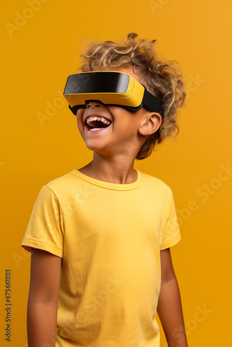 Young boy getting experience using VR headset glasses isolated on a yellow background