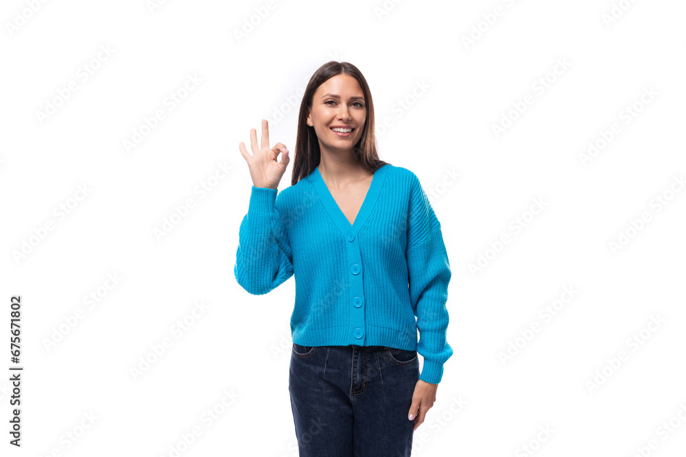 young pretty brunette lady dressed in a blue V-neck sweater on a white background with copy space young pretty brunette lady dressed in a blue V-neck sweater on a white background with copy space
