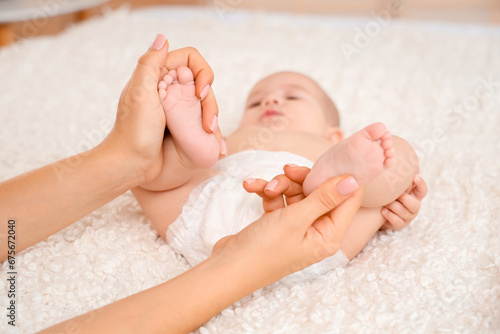 Mother massaging her baby's...
