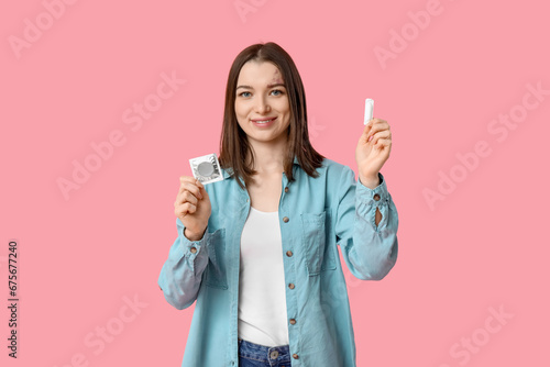 Принти на полотні Beautiful young woman with suppository and condom on pink background