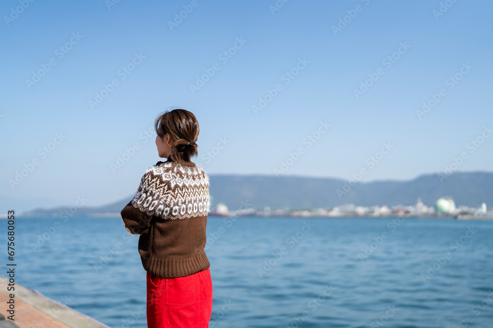 海を散策するニットを着た女性 海を散策するニットを着た女性