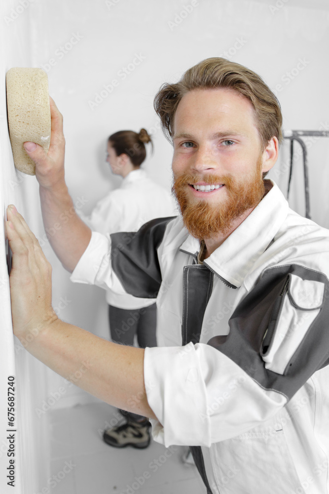 male decorator using sponge on interior wall male decorator using sponge on interior wall