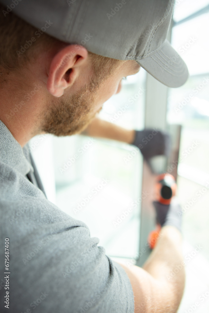 Fototapeta premium professional handyman fixing window handle at home