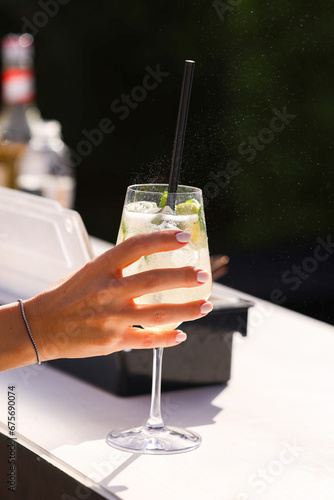 Hugo cocktail alcoholic aperitif. Photo while a bartender prepares Hugo cocktails drinks with prosseco lime ice, elderflower syrup and mint. Dark background. photo