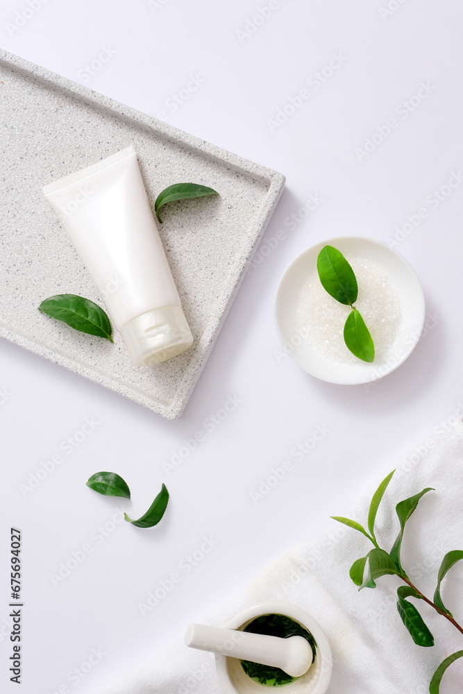 The white tube of facial cleanser is placed on a ceramic tray. A small white mortar holds green tea extract. Catechin - a main ingredient in green tea leaves, has the effect of shrinking pores. The white tube of facial cleanser is placed on a ceramic tray. A small white mortar holds green tea extract. Catechin - a main ingredient in green tea leaves, has the effect of shrinking pores.
