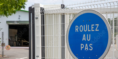 roulez au pas sign french text traduction Drive slowly road panel blue round in France photo