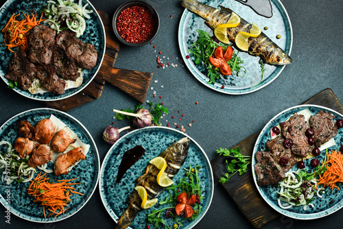 A set of meat dishes: shish kebab, kebab, steak, fish. On a black background. Top view. Free space for text.