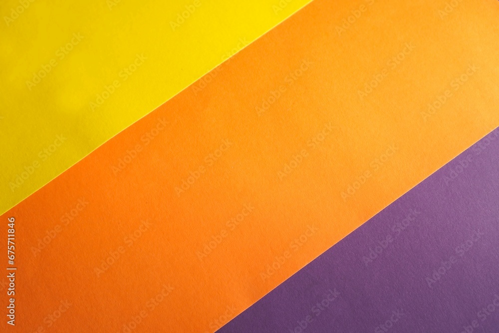 background of multicolored paper parallel stripes of orange, yellow and purple colors