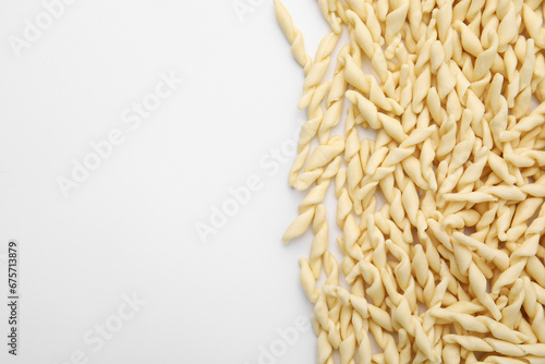 Uncooked trofie pasta on white background, flat lay. Space for text photo