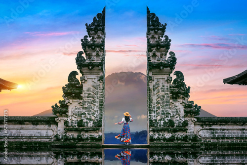 Young woman standing in temple gates at Lempuyang Luhur temple in Bali, Indonesia. photo