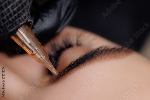 Procedure Permanent makeup tattoo for eyebrows. Detail of beautiful woman with black brows in beauty salon