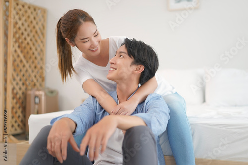 Asian young couple woman hugging man from behind  with positive emotion lover. Attractive Husband with Wife embracing spending time together at home. Relationship of feeling in love.