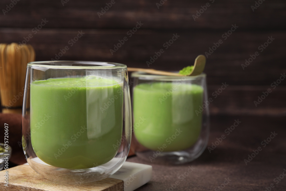 Glass of tasty matcha smoothie on brown table, closeup. Space for text Glass of tasty matcha smoothie on brown table, closeup. Space for text