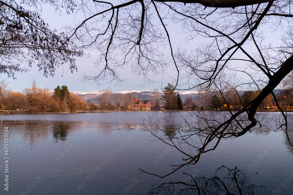 frozen lake with a palace in the background during sunset
