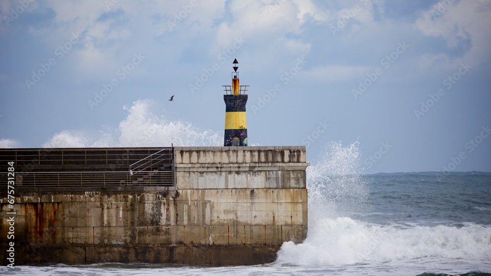 Obraz premium wave breaks against the lighthouse