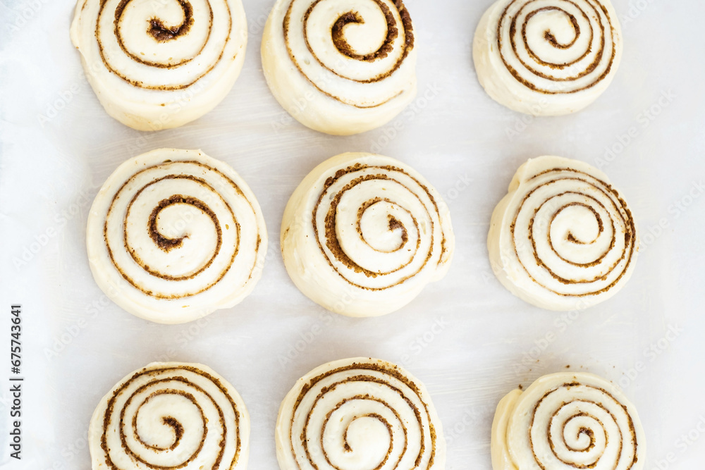 Raw, unbaked cinnamon buns resting. Cooking of healthy buns from alternative flours. Vegan bread. Festive food. top view.