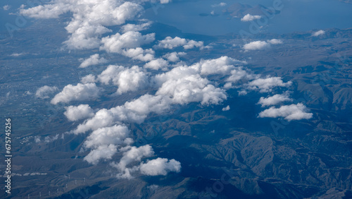 An aerial view of white clouds circling in the sky with mountainous vistas above Hokkaido Japan.