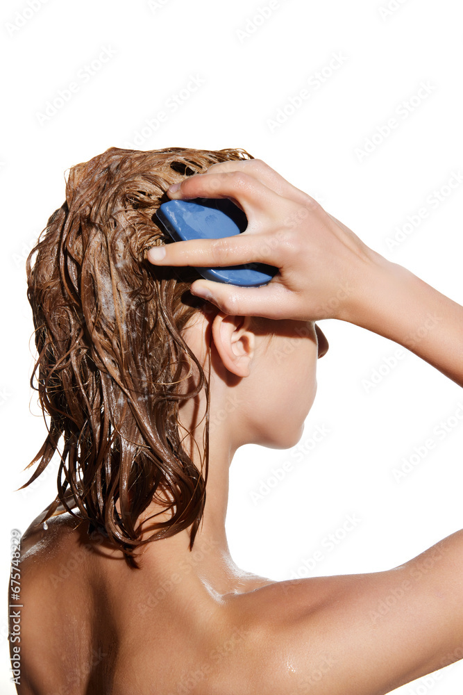 Naklejka premium Side view of girl with wet hair with shampoo, massaging head with hair brush against white studio background. Concept of beauty, hair care, treatment, natural cosmetics. Copy space for ad